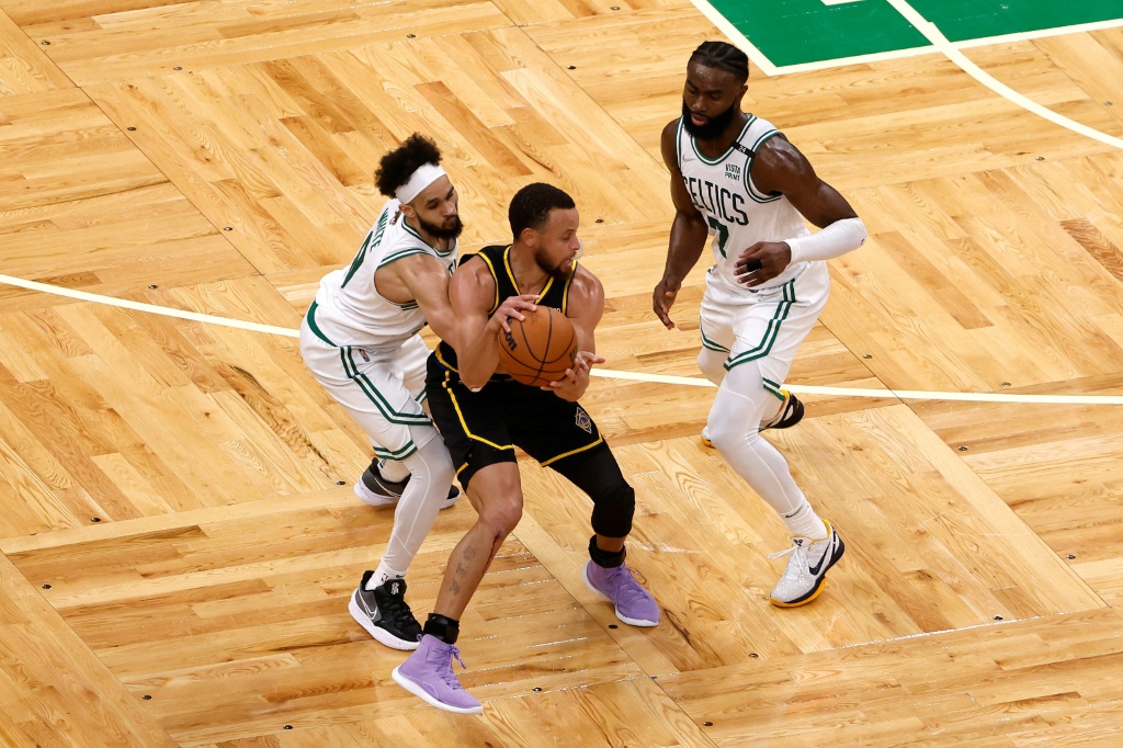 Stephen Curry, des Golden State Warriors, aux prises avec Derrick White et Jaylen Brown (N.7) au cours du match 4 de la finale NBA le 10 juin 2022 à Boston