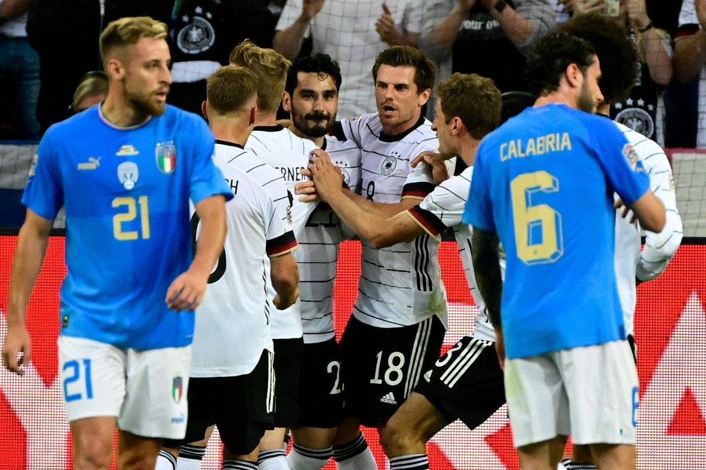 Le milieu de terrain allemand Ilkay Gundogan (c), félicité par ses coéquipiers, après avoir marqué le 2e but sur penalty face à l'Italie, lors de leur match de Ligue des nations, le 14 juin 2022 à Moechengladbach
