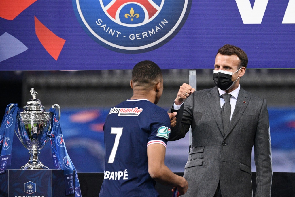 Kylian Mbappé, l'attaquant du PSG et de l'équipe de France de football, félicité par le président Emmanuel Macron, après la victoire de Paris face à Monaco en finale de la Coupe de France, le 10 mai 2021 au Stade de France à Saint-Denis