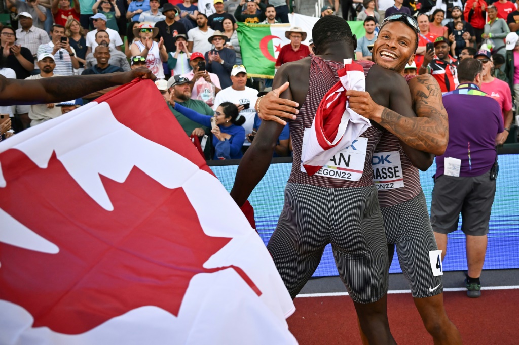 Andre De Grasse félicité par ses équipiers après la victoire du relais canadien en finale du 4x100 m aux championnats due monde d'athlétisme de Eugene, aux Etats-Unis, le 23 juillet 2022