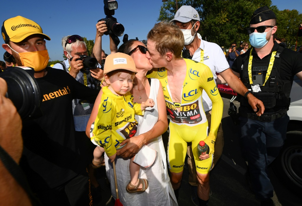Le Danois Jonas Vingegaard embrasse sa compagne Trine, à côté de sa fille Frida, après avoir terminé 2e du contre-la-montre de la 20e étape du Tour de France, entre Lacapelle-Marival et Rocamadour, le 23 juillet 2022, derrière son coéquipier, le Belge Wout van Aert