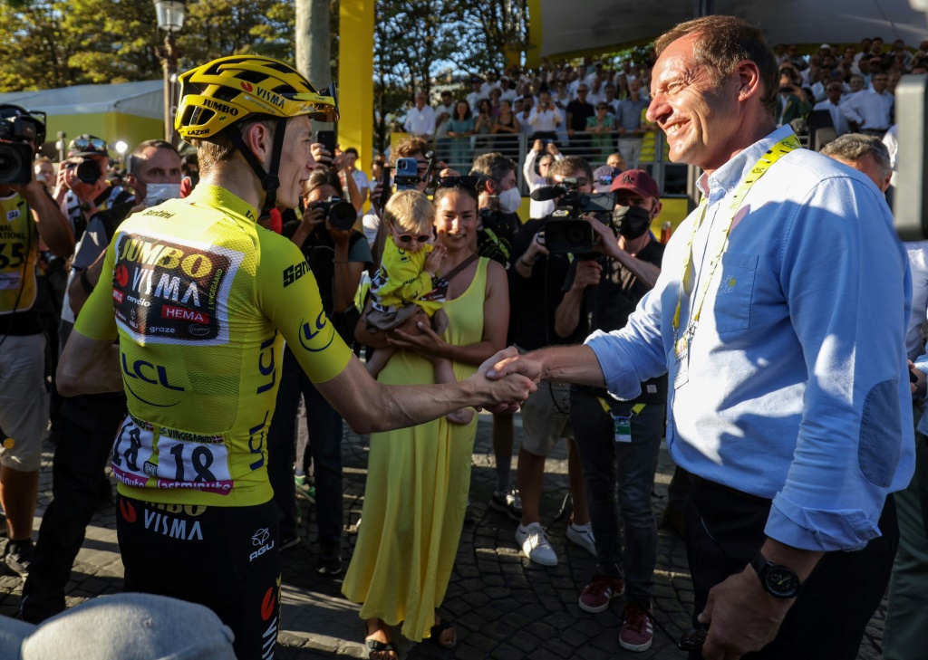 Le directeur du Tour de France Christian Prudhomme félicite le maillot jaune Jonas Vingegaard, vainqueur de la 109e édition à Paris, le 24 juillet 2022