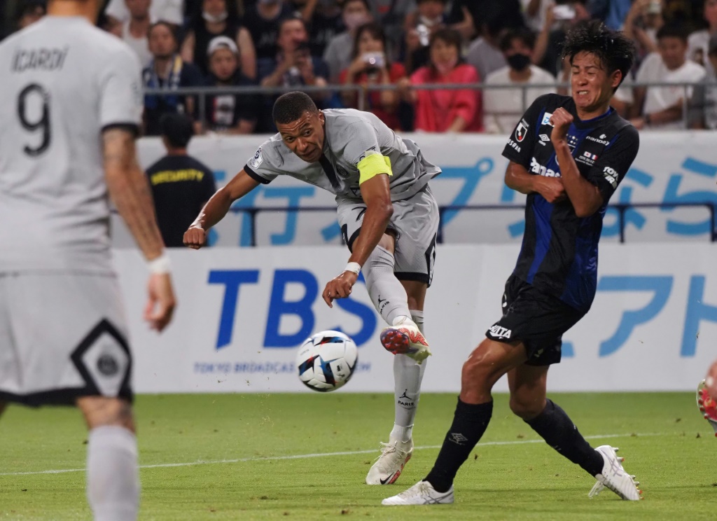 L'attaquant star du PSG Kylian Mbappé expédie une frappe contre l'équipe de Gamba, dernier match du Japan Tour à Osaka, le 25 juillet 2022