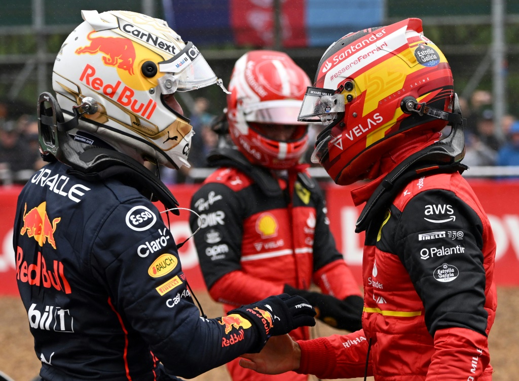 Le Néerlandais Max Verstappen (g) félicite Carlos Sainz (d) pour sa pole position, sous les yeux du Monégasque Charles Leclerc (c), le 2 juillet 2022 à Silverstone