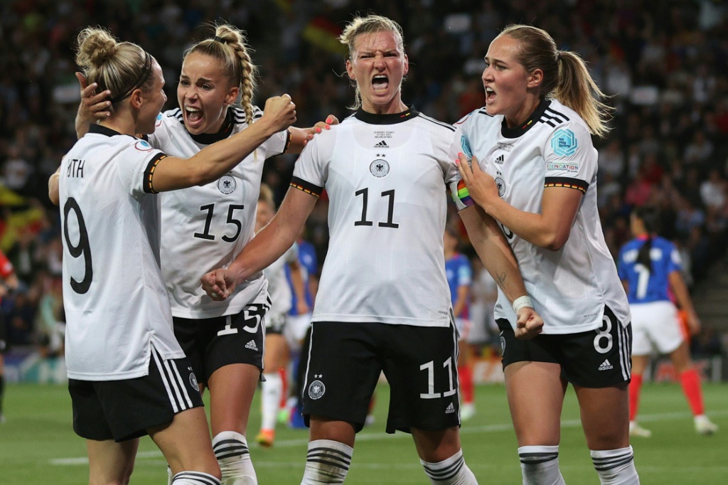 La joie de la capitaine et attaquante allemande Alexandra Popp (c)), félicitée par ses coéquipières, après avoir marqué le 2e but face à la France, lors de leur demi-finale de l'Euro, le 27 juillet 2022 à Milton Keynes (Angleterre)