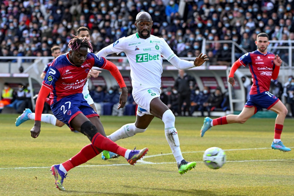 L'attaquant de Clermont Mohamed Bayo tire malgré le retour du défenseur stéphanois Eliaquim Mangala, lors de la 24e journée de Ligue 1, le 13 février 2022 au Stade Gabriel Montpied