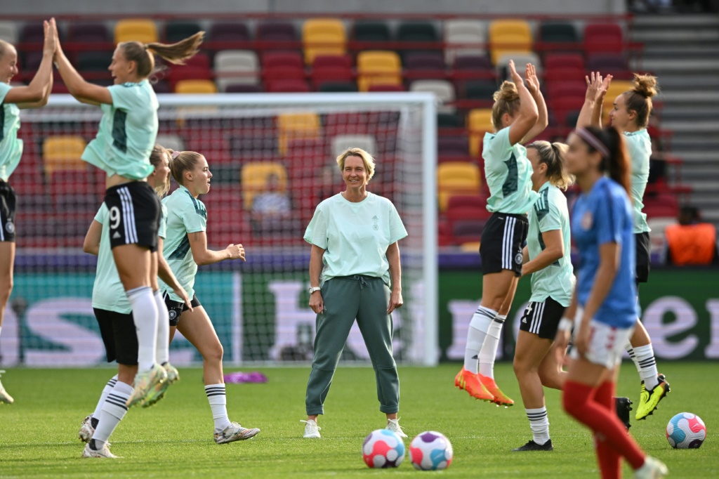 La sélectionneuse allemande Martina Voss-Tecklenburg observe ses joueuses à l'échauffement, avant leur match de poules de l'Euro contre le Danemark, le 8 juillet 2022 à Brentford