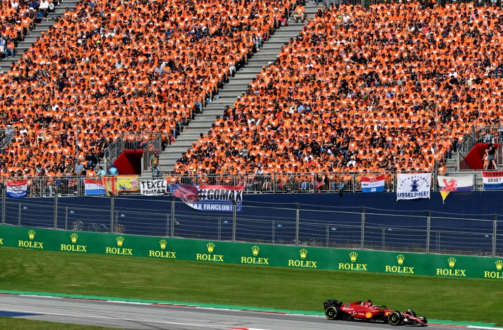 La Ferrari du Monégasque Charles Leclerc, passe devant la foule de supporteurs néérlandais, venus soutenir Max Verstappen, au GP de F1 d'Autriche, le 10 juillet 2022 à Spielberg