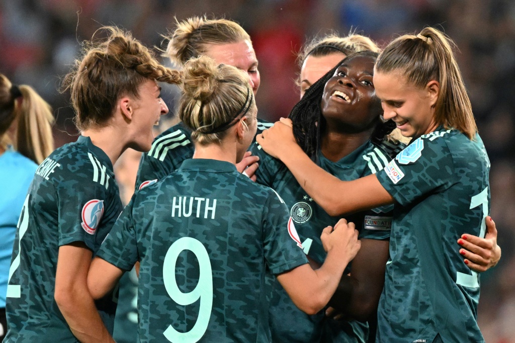 La milieu de terrain allemande Nicole Anyomi est félicitée par ses coéquipières, après avoir marqué le 3e but face à la Finlande, lors de leur match de poule de l'Euro, le 16 juillet 2022 à Milton Keynes, au nord de Londres