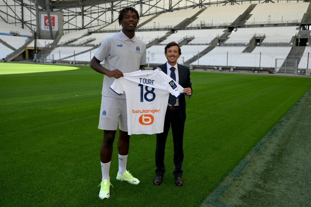 Le nouveau défenseurs de l'Olympique de Marseille, Isaak Touré pose à côté du président de l'OM, l'Espagnol Pablo Longoria, lors de sa présentation officielle, le 19 juillet 2019 au Stade Vélodrome