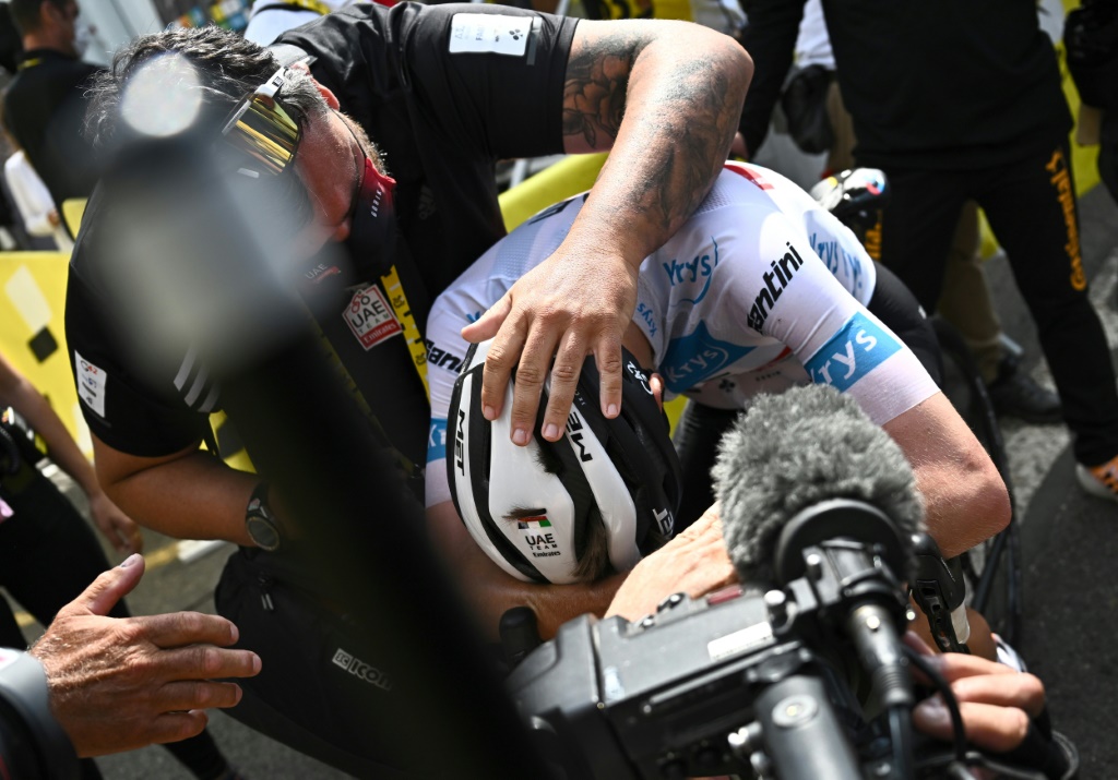 Le Slovène Tadej Pogacar, effondré sur son vélo, après avoir remporté la 17e étape du Tour de France, le 22 juillet 2022 à l'altiport de Peyragudes, devant le maillot jaune, le Danois Jonas Vingegaard