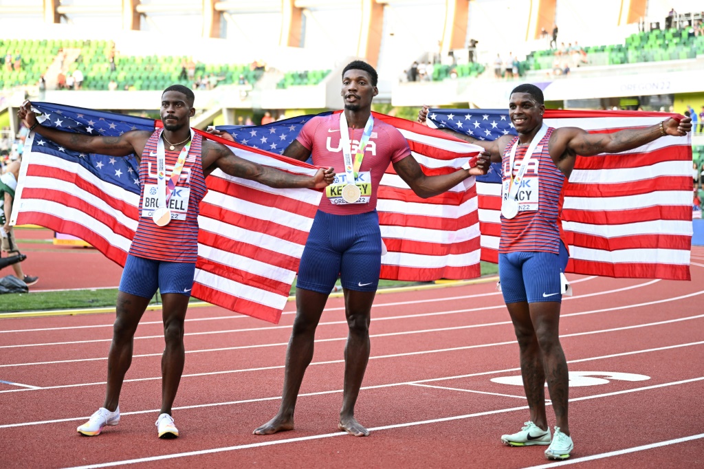 L'Américain Fred Kerley, champion du monde du 100 m pose, entouré de ses compatriotes Trayvon Bromell (g, argent) et Marvin Bracy (bronze), le 16 juillet 2022 à Eugene (Oregon)