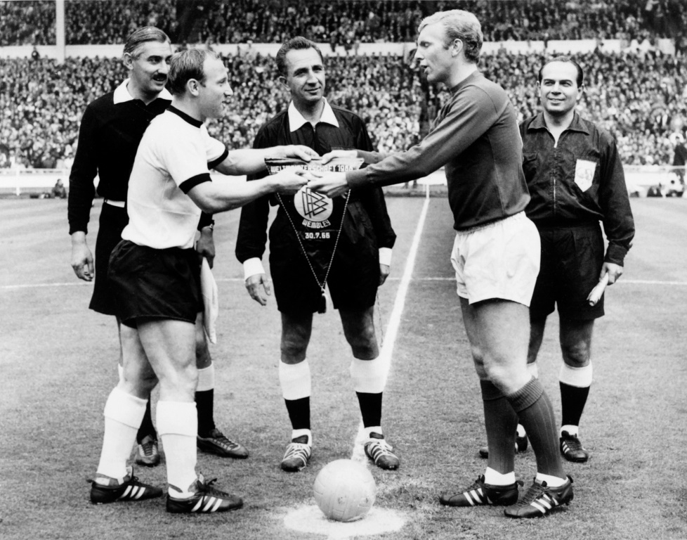 Le capitaine et attaquant allemand Uwe Seeler et son homologue anglais, le défenseur Bobby Moore échangent leurs fanions, avant le coup d'envoi de la finale de la Coupe du monde, le 30 juillet 1966 au Stade de Wembley à Londres