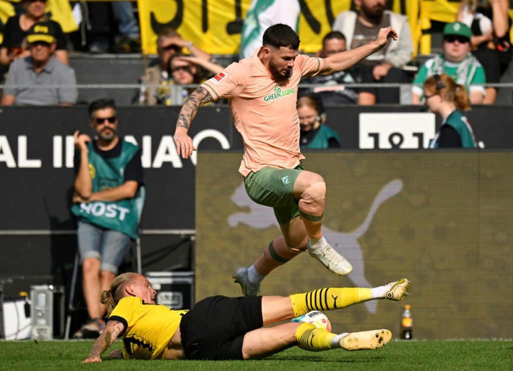 Le milieu de terrain de Dortmund Marius Wolf (en bas) à la lutte avec Oliver Burke du Werder Breme lors du match de Bundesliga le 20 aoput 2022 à Dortmund