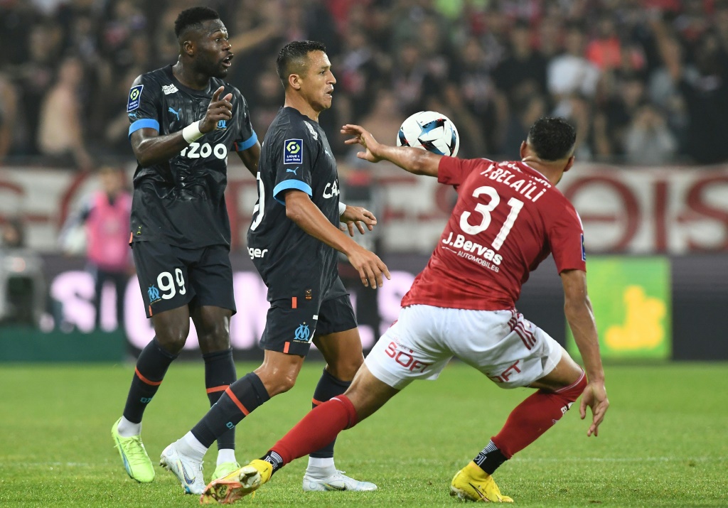 L'attaquant chilien de l'Om Alexis Sanchez (au centre) tente de passer Youcef Belaïli lors du match nul de l'OM à Brest