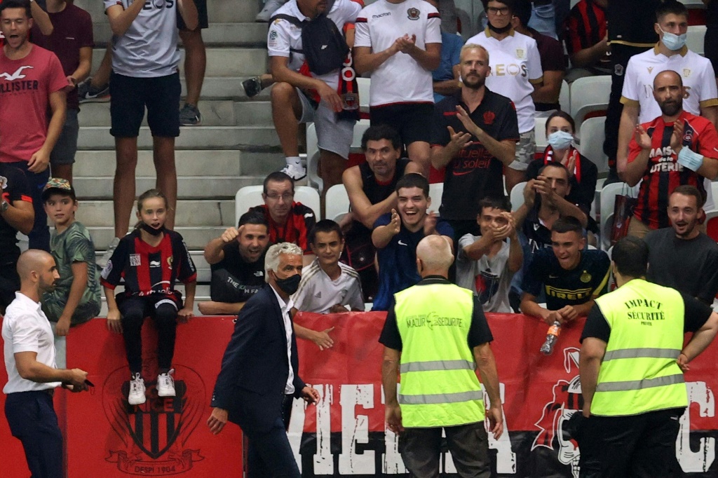 Le président niçois Jean-Pierre Rivère (masque) tente de raisonner les suporters après l'arrêt du match contre Marseille à Nice, le 22 août 2021