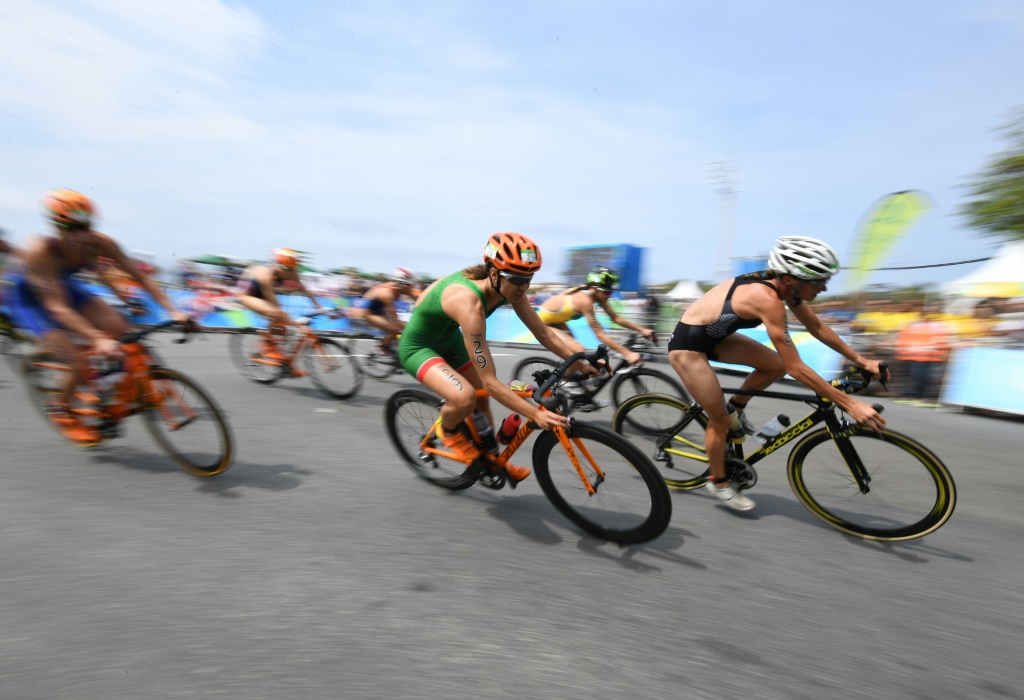 Des compétitrices passent devant des spectateurs, lors de l'épreuve de cyclisme du triathlon femmes aux Jeux olympiques de Rio, le 20 août 2016
