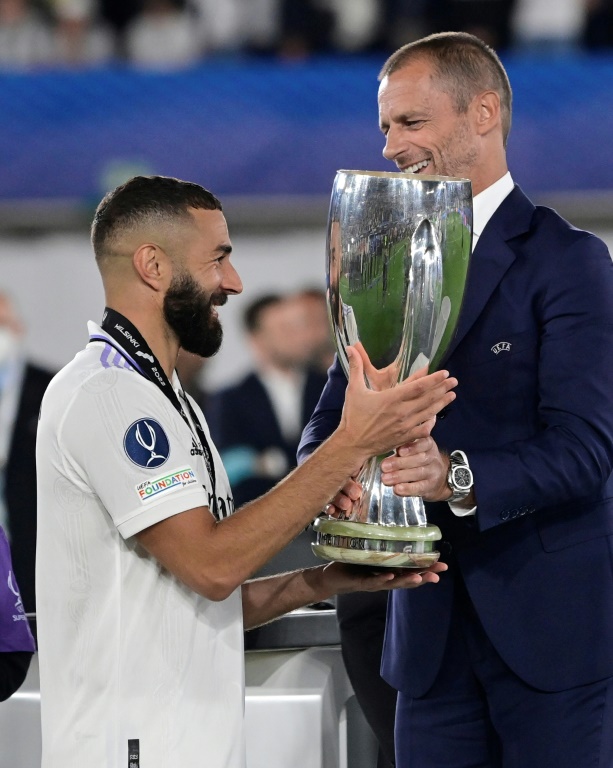 Le capitaine du Real Madrid Karim Benzema reçoit des mains  du patron de l'UEFA Aleksander Ceferin le trophée de la Supercoupe d'Europe à Helsinki, le 10 août 2022