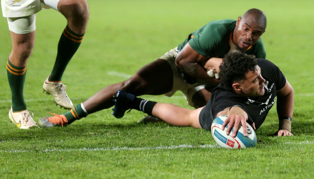 Le centre de la Nouvelle-Zélande David Havili résiste à l'ailier de l'Afrique du Sud Makazole Mapimpi pour inscrire un essai du bout du bras lors de la victoire des All Blacks dans le Rugby Championship le 13 août 2022 à l'Ellis Park de Johannesburg