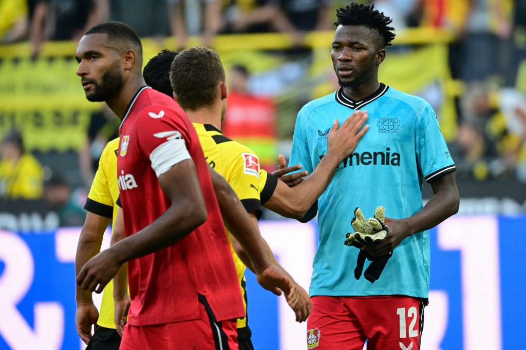 Le défenseur de Leverkusen Edmond Tapsoba enfile le maillot et les gants pour suppléer son gardien exclu à Dortmund, le 6 août 2022