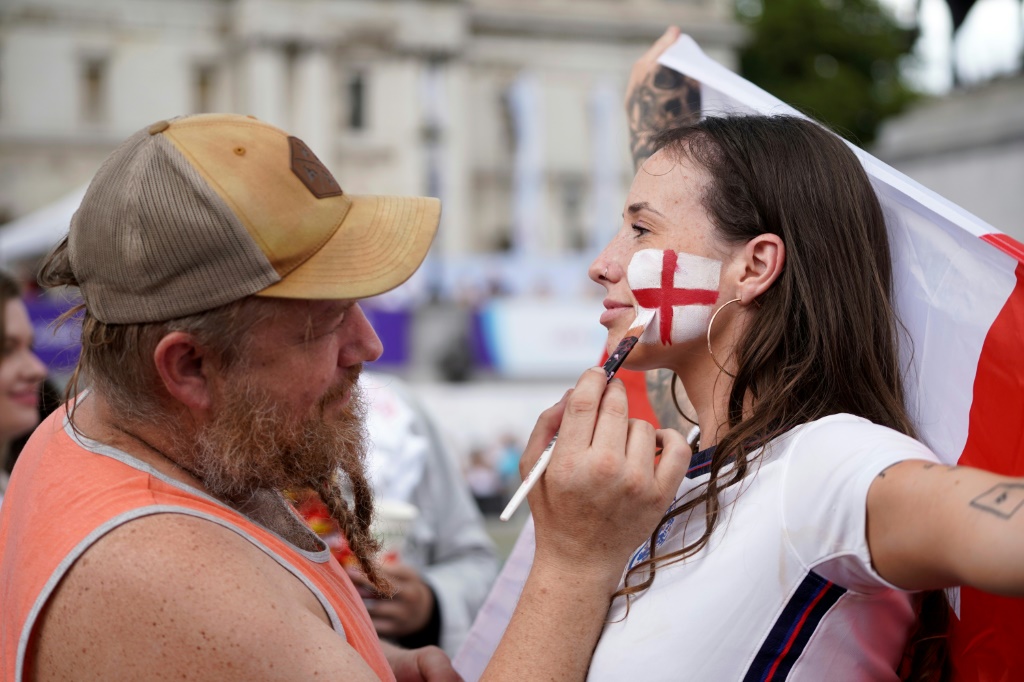 Une jeune supporter anglaise se fait maquiiller aux couleurs de son équipe à Trafalgar Square avant la finale contre l'Allemagne, le 31 juillet 2022