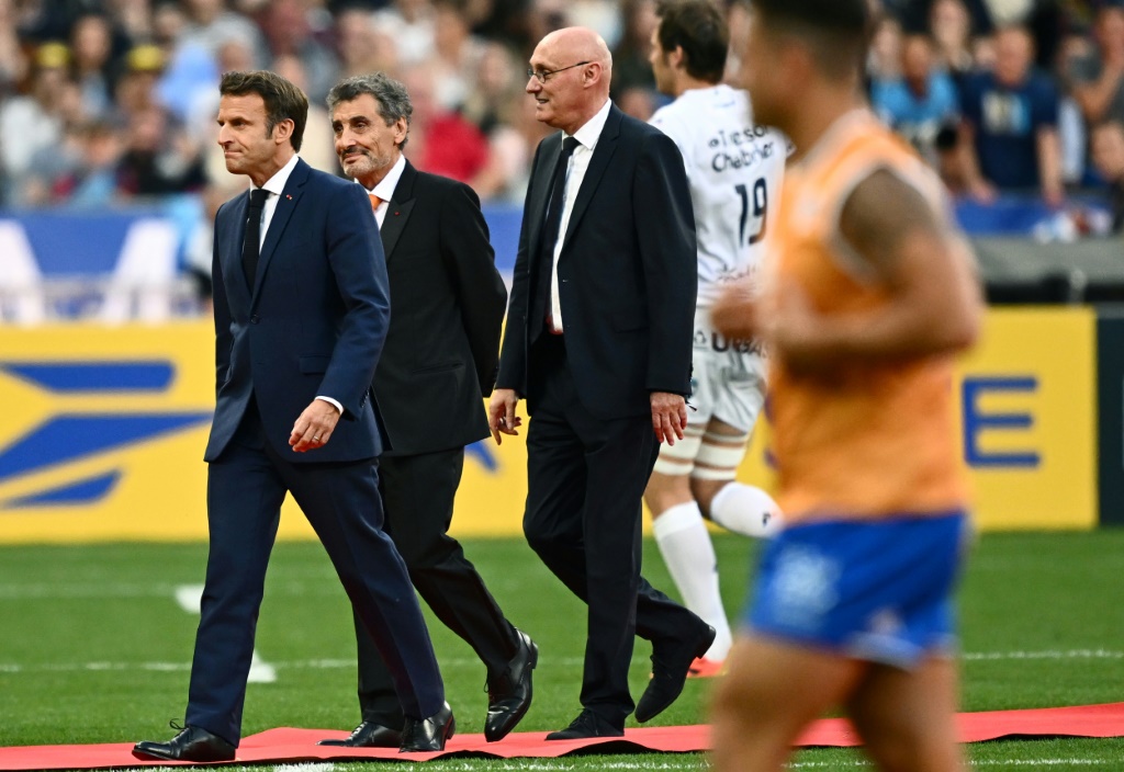 Le président Emmanuel Macron (G) aux côtés deu président du Montpellier Hérault rugby Mohed Altrad (C) et de Bernard Laporte (D) avant la finale du Top14 entre Castres et Montpellier au Stade de France