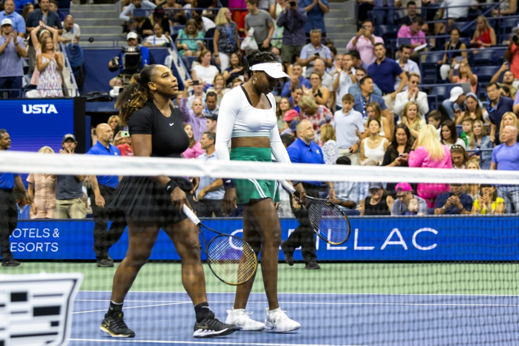 Serena Williams (g) et sa soeur Venus Williams quittent le court après leur défaite au 1er tour du double féminin de l'US Open face à la paire tchèque Lucie Hradecka/Linda Nsokova