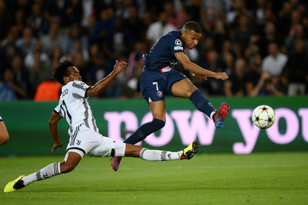 L'attaquant français du Paris SG Kylian Mbappé frappe devant le défenseur colombien de la Juventus Turin Juan Cuadrado lors du match de la 1ere journée de la Ligue des champions dans le groupe H entre le PSG et la Juve, le 6 septembre 2022 à Paris.