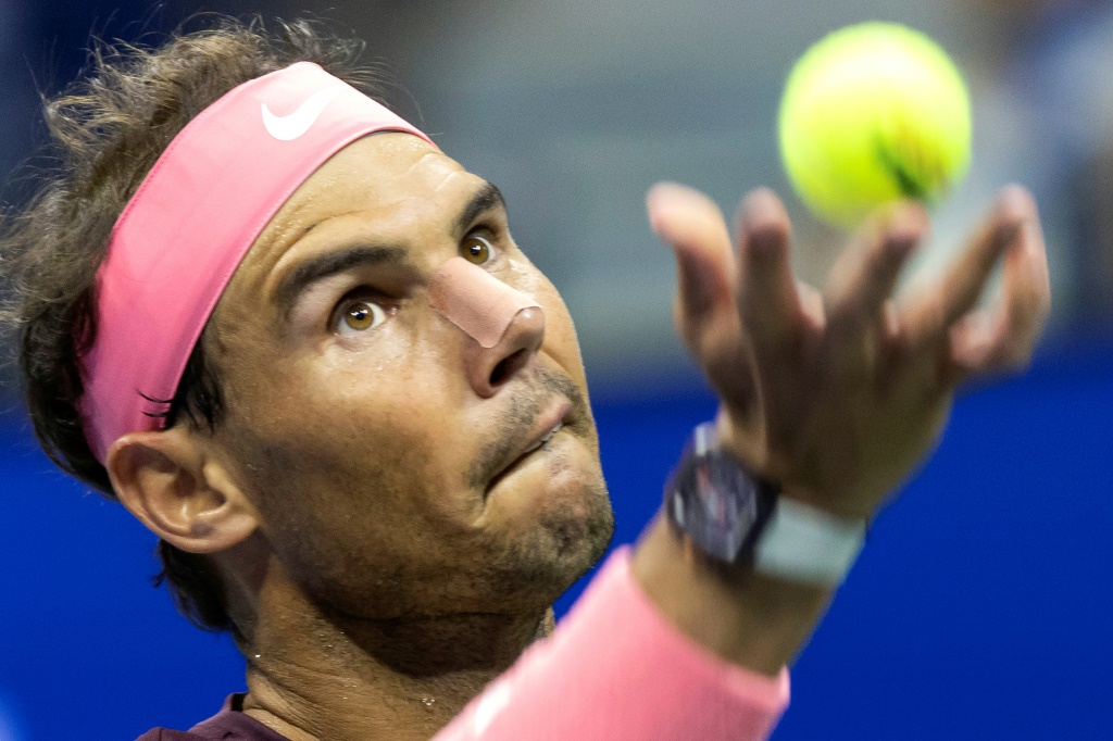Pansement sur le nez après un coup de raquette, Rafale Nadal au service face à l'Italien Fabio Fognini pendant leur rencontre du second tour de l'US Open, le  1er septembre 2022 à New York.