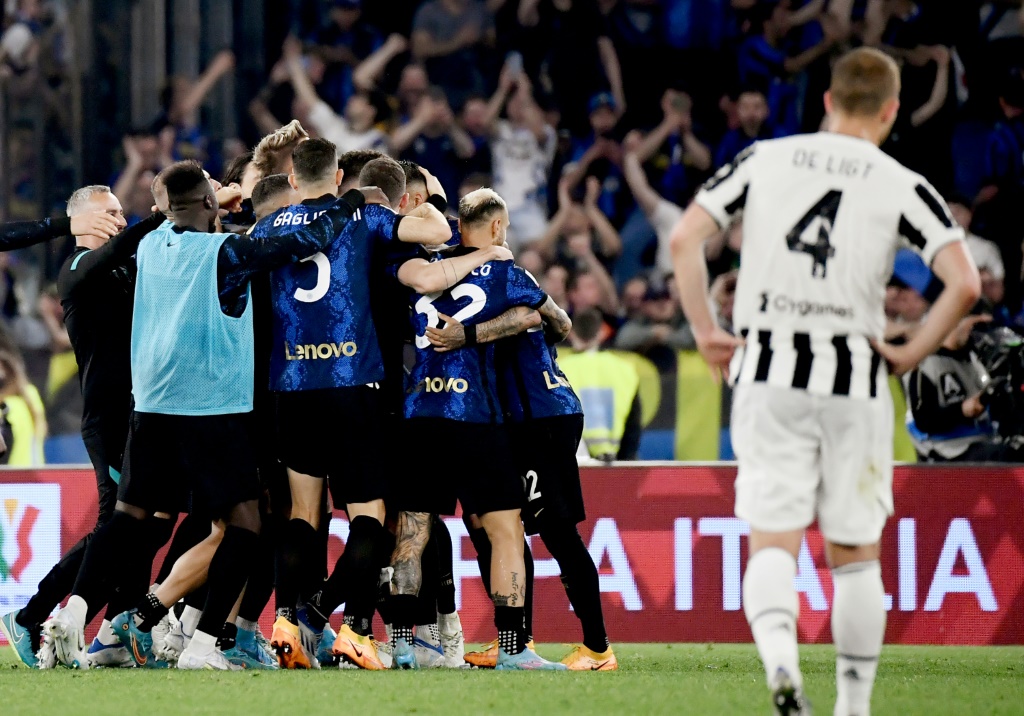 Les joueurs de l'Inter Milan (à l'arrière plan) célèbrent leur victoire en finale de la Coupe d'Italie face à la Juventus de Matthijs De Ligt  (à droite au premier plan) le 11 mai 2022 au stade olympique de Rome