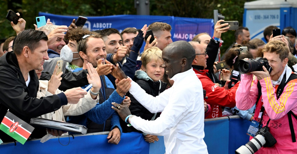 Le Kényan Eliud Kipchoge (au centre) est félicité par des spectateurs après sa victoire au marathon de Berlin, le 25 septembre 2022