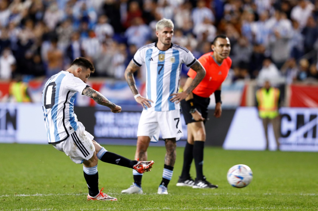 Le capitaine de l'Argentine Lionel Messi (g) inscrit un but sur coup franc contre la Jamaïque en match amical, à Harrison, aux Etats-Unis, le 27 septembre 2022