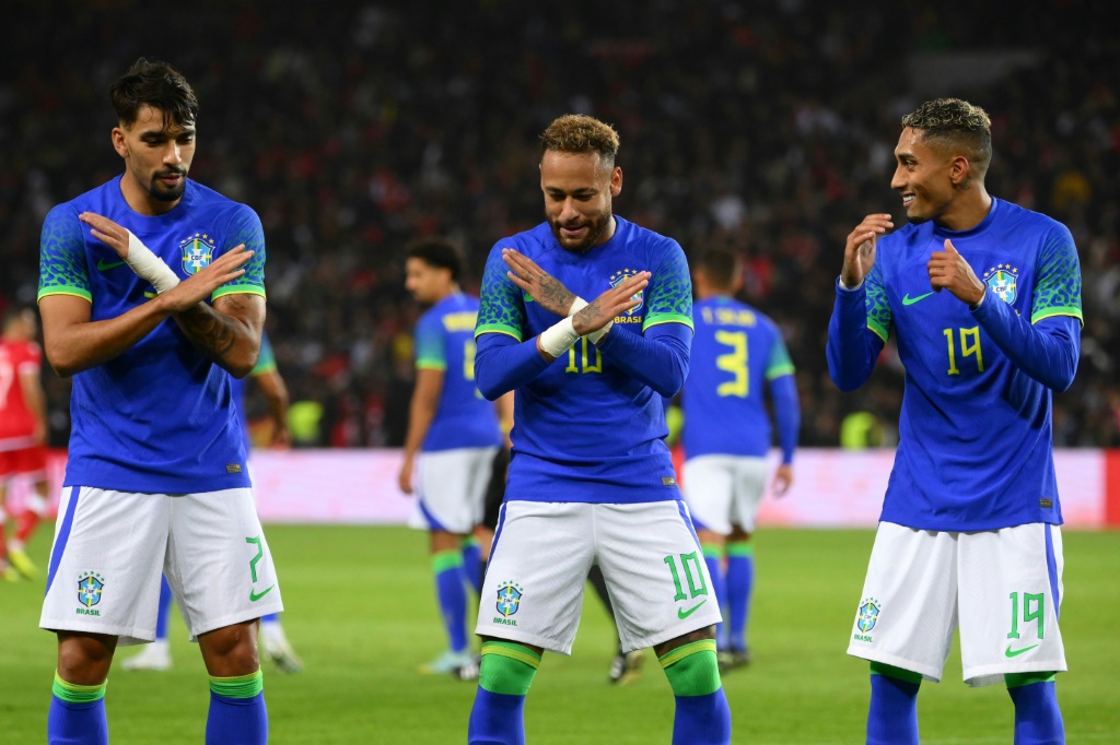 Les Brésiliens Paquetà, Neymar et Raphinha exécutent une petite danse après le troisième but de leur équipe, en match amical contre la Tunisie, le 27 septembre 2022 à Paris