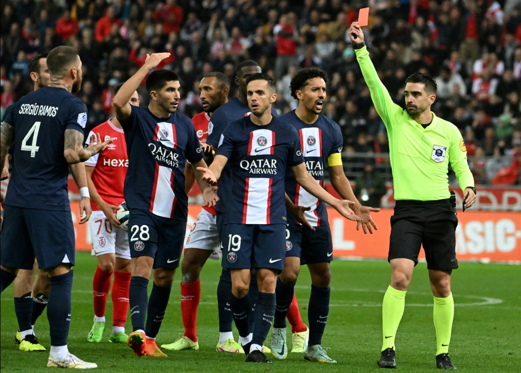 L'arbitre Pierre Gaillouste (d) adresse un carton rouge au Parisien Sergio Ramos (g) lors du match à Reims