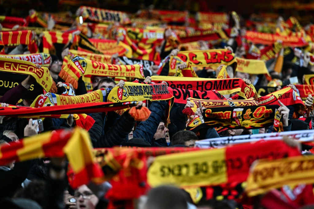 Les supporters de l'équipe de football de Lens brandissent leurs écharpes aux couleurs du club lors du match de Ligue 1 disputé contre l'Olympique lyonnais au Stade Bollaert-Delelis à Lens le 2 octobre 2022.