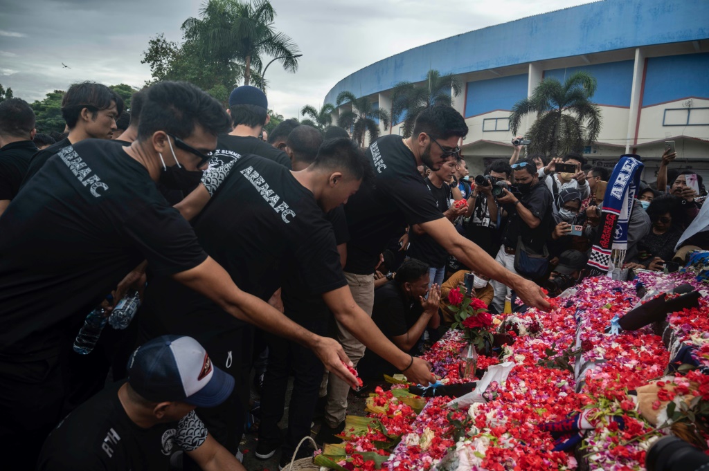 Des joueurs et des responsables du club de foot indonésien Arema FC rendent hommage aux victimes d'une bousculade meurtrière dans le stade Kanjuruhan, à Malang le 3 octobre 2022