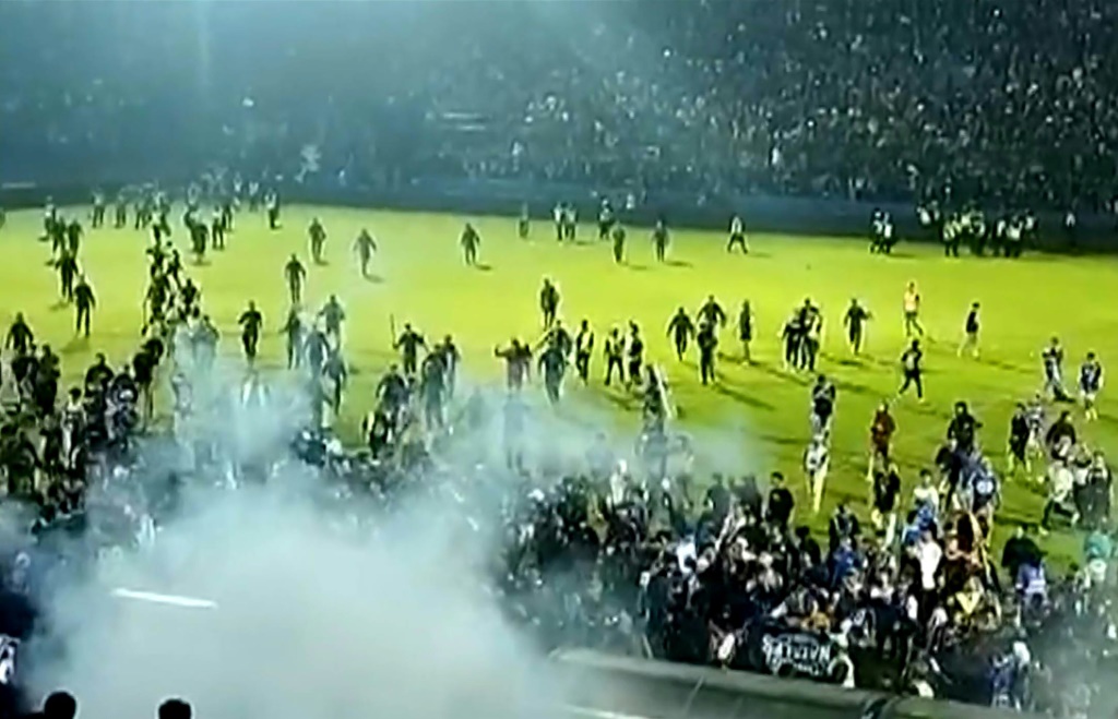 Capture d'écran d'une vidéo de l'AFPTV réalisée le 1er octobre 2022 montrant des gaz lacrymogènes tirés sur la foule lors d'un match, à Malang en Indonésie