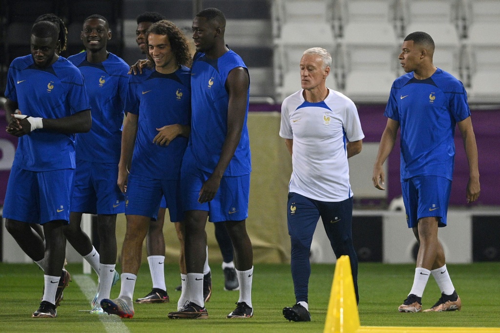 Le Français Didier Deschamps (au centre) au milieu de ses joueurs dont Kylian Mbappé (à droite) pendant une séance d'entraînement à Doha le 21 novembre 2022 avant les débuts de la France dans le Mondial au Qatar