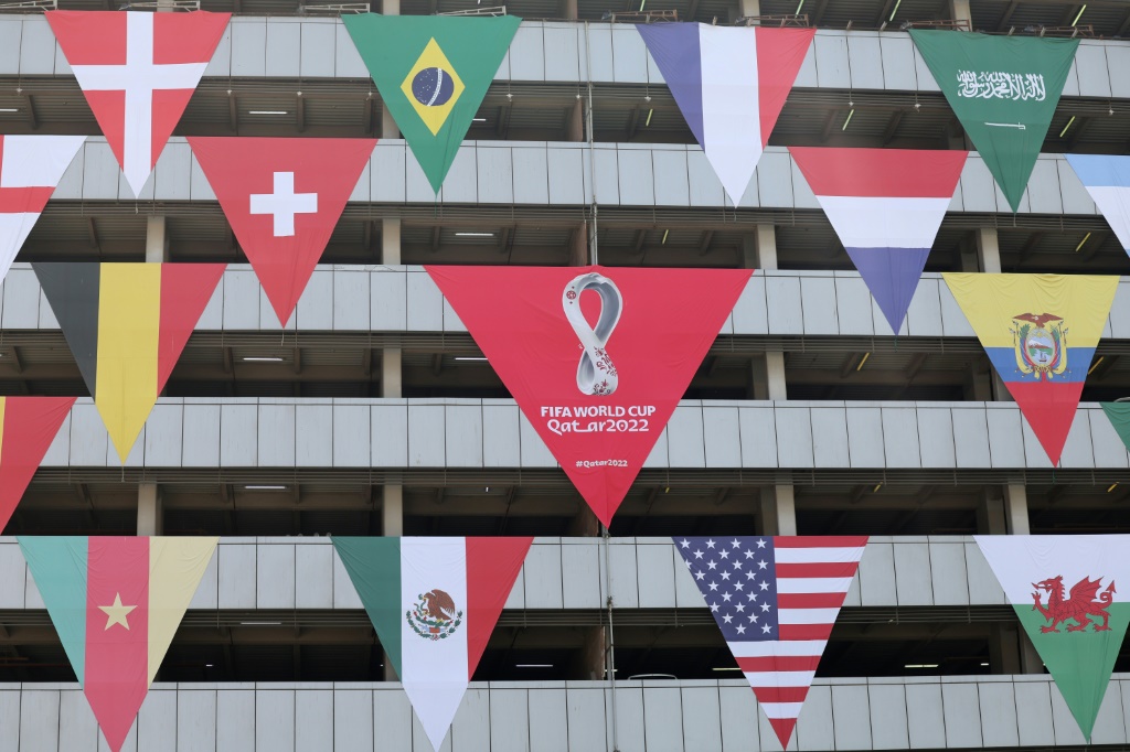 Les drapeaux des nations qualifiées pour le Mondial-2022 devant un immeuble de Doha