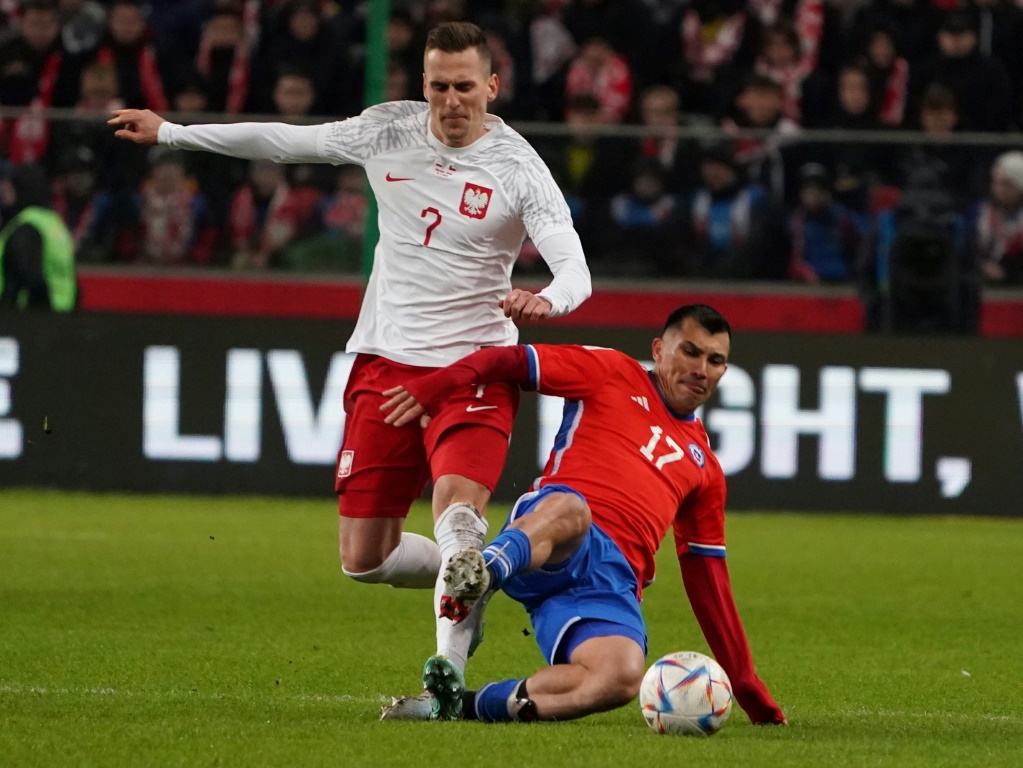 Le polonais Arkadiusz Milik (G) et le chilien Gary Medel se disputent le ballon lors du match amical de football entre la Pologne et le Chili à Varsovie le 16 novembre 2022