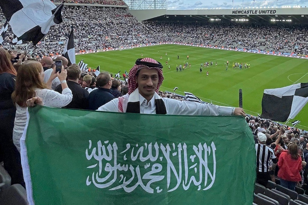 Abdelrahman al-Qahtani, un supporter de Newcastle, pose avec un drapeau saoudien lors d'un match entre les Magpies et Nottingham Forest à St James' Park, le 6 août 2022