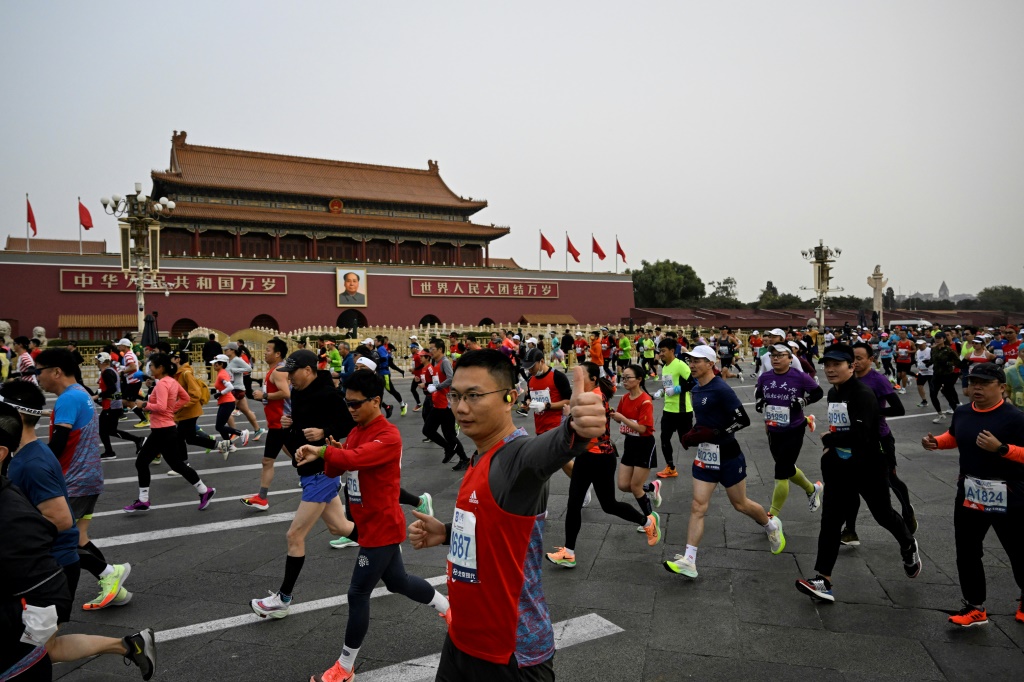 Des participants au marathon de Pékin, le premier depuis 2019 en raison de Covid, passent sur la place Tiananmen, le 6 novembre 2022