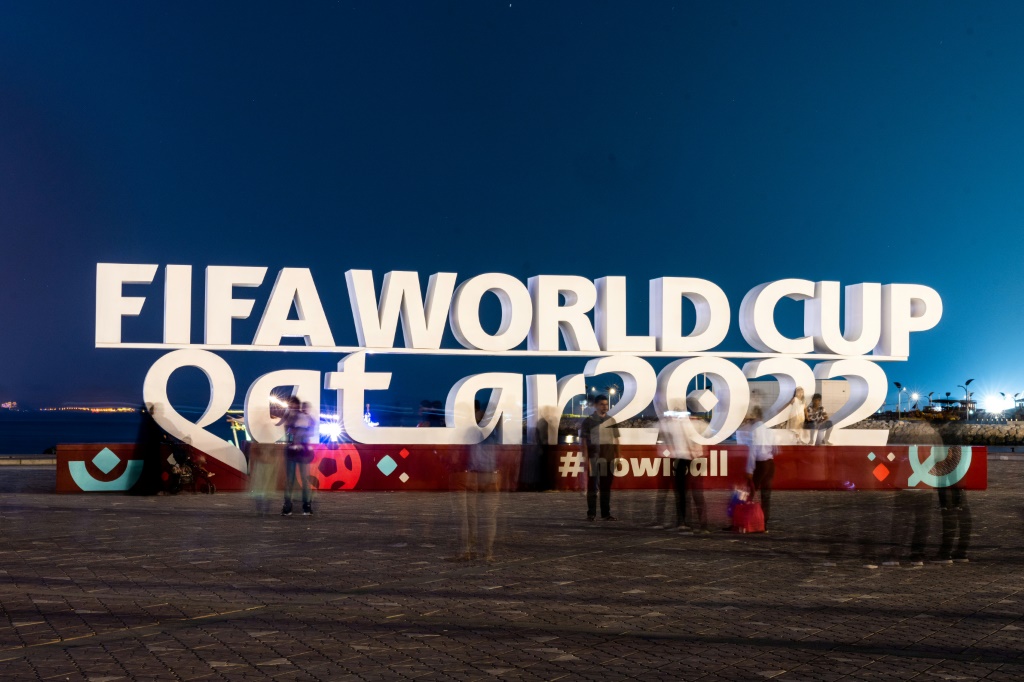 Des visiteurs photographient le logo de la Coupe du monde de la Fifa au Qatar à Doha, le 30 octobre 2022