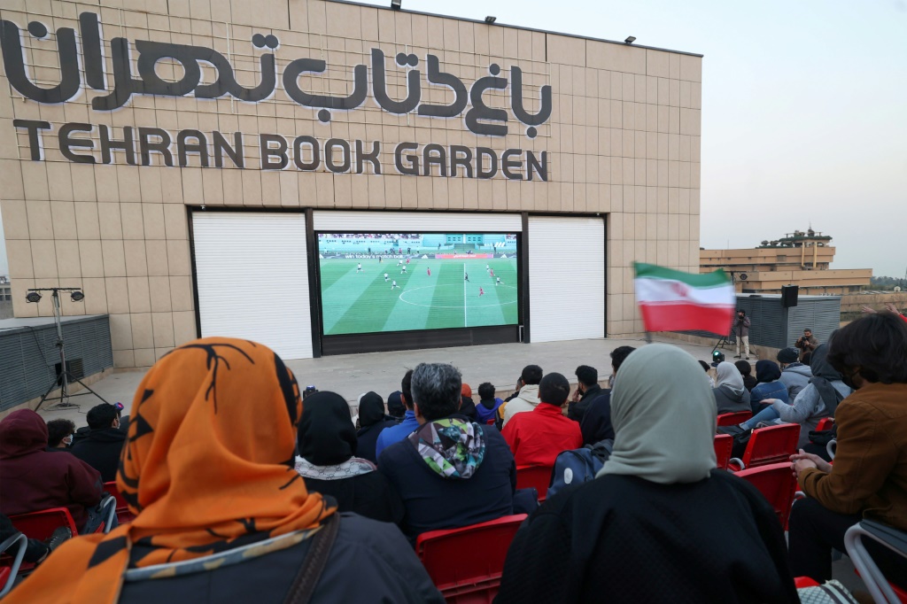 Des supporters et supportrices de l'équipe d'Iran regardent leur match du Mondial contre l'Angleterre, près de la bibliothèque nationale à Téhéran, le 21 novembre 2022