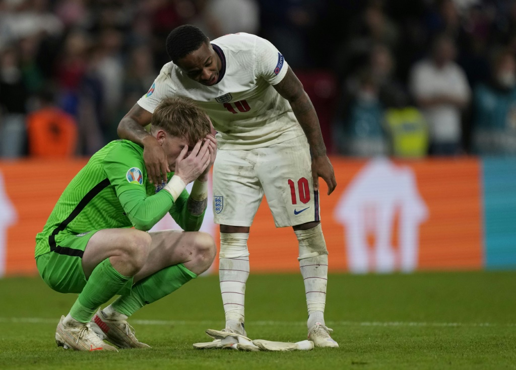 Raheem Sterling réconforte le gardien anglais Jordan Pickford après leur défaite devant l'Italie en finale de l'Euro à Wembley, le 11 juillet 2021