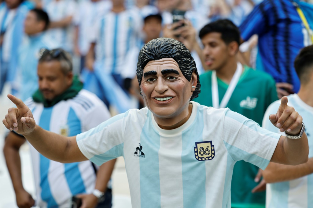 Un supporter argentin porte un masque à l'effigie de Diego Maradona à Doha le 22 novembre 2022