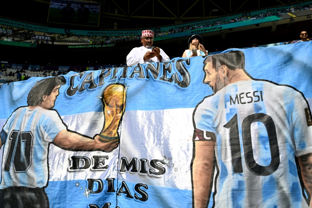 Des supporters argentins déploient une banderole avec Diago Maradona et Lionel Messi le 22 novembre à Doha