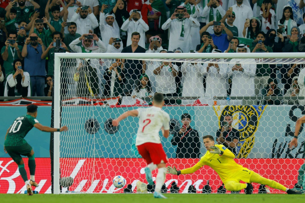 Le gardien polonais Wojciech Szczesny repousse le penalty du Saoudien Salem Al-Dawsari, lors du Mondial au Qatar, le 26 novembre 2022 au stade Education City à Doha