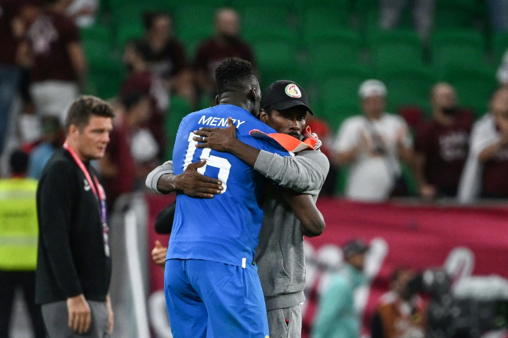Le sélectionneur du Sénégal Aliou Cissé félicite son gardien Edouard Mendy, à l'issue du match contre le Qatar, lors du Mondial, le 25 novembre 2022 au stade Al-Thumama à Doha