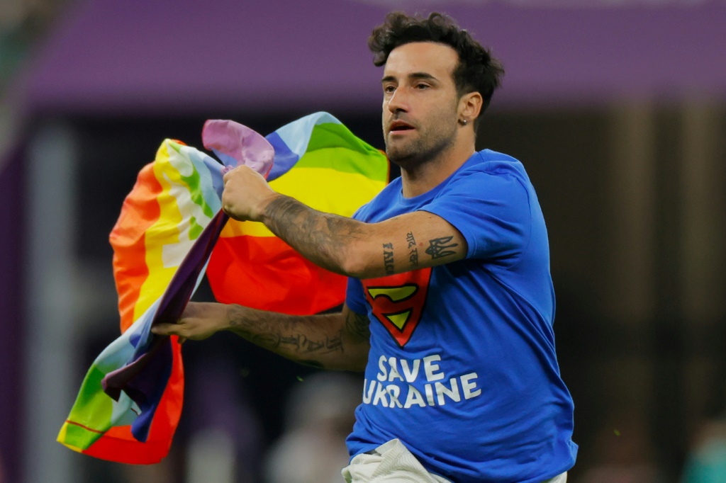 Un homme portant un drapeau arc-en-ciel et vêtu d'un tee-shirt de soutien aux femmes iraniennes et à l'Ukraine a pénétré le 28 novembre 2022 sur la pelouse du stade de Doha pendant la rencontre du Mondial-2022 entre le Portugal et l'Uruguay